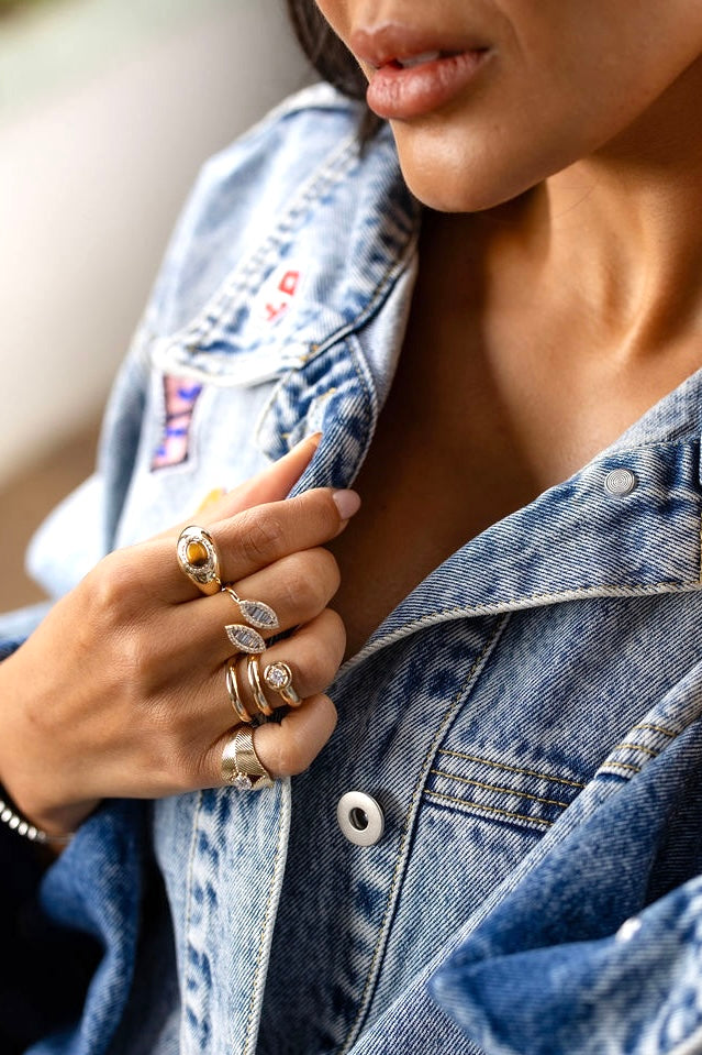 Détails de bagues Goldie Paris portées sur une veste en jean